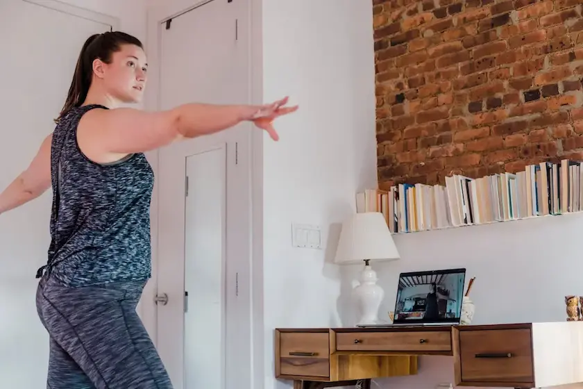 A woman with a ponytail exercising at home.