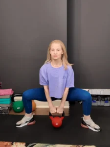 Woman demonstrating the plié squat.